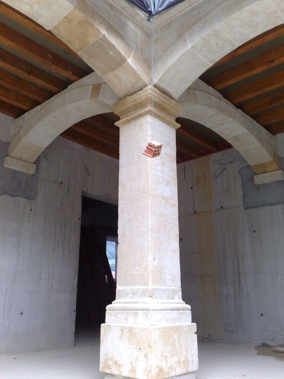 Columna de Piedra y Arcos Cruzados en Construcción